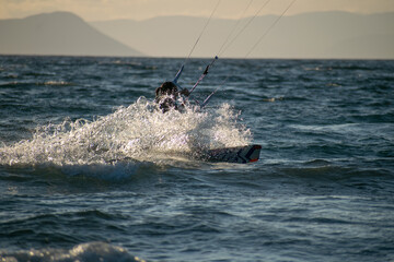 Obraz premium Woman kitesurfer athlete splashes on sea waves