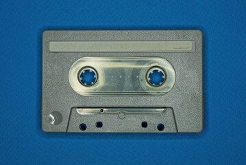 one gray old plastic audiotape lies on the blue table