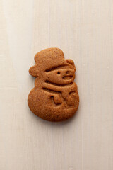 snowman gingerbread cookie isolated on white wooden background