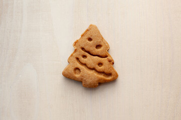 christmas tree shaped cookie on white wooden background