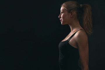 Fototapeta premium profile portrait of model on a black background in studio and the light coming from the left 