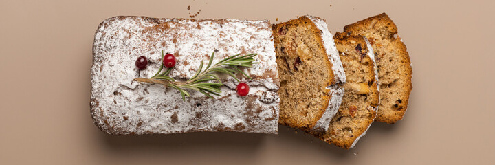 Fresh sliced Christmas muffin with dried fruits and nuts on a beige background minimalism