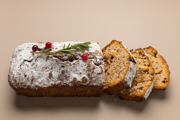 Fresh sliced Christmas muffin with dried fruits and nuts on a beige background minimalism