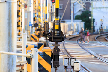 遮断機のある踏切を渡る歩行者