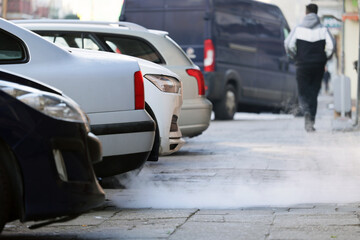  Niebezpieczny dym wylatuje z komina samochodu jadącego w korku w mieście.