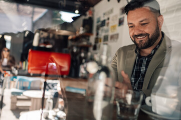 Businessman using a smartphone while drinking coffee in a cafe