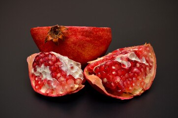 juicy red pomegranate with seeds on a black background