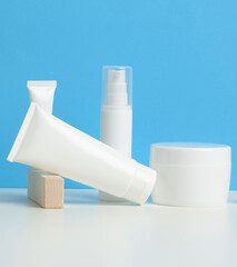 bottle and empty white plastic tubes for cosmetics on a white background. Packaging for cream, gel, serum, advertising and product promotion