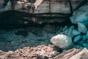 Scenic highland landscape with powerful mountain river beginning from glacier with ice chunks. Beautiful scenery with glacier at source of turbulent glacial river. Mountain river among big ice blocks.
