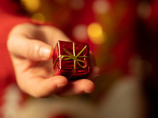 dawać prezent - dłoń trzymająca mały prezent, prezent świąteczny, święta bożego narodzenia