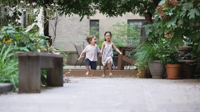 Happy kids running while holding hands, diversity multiracial friendship concept in slow motion