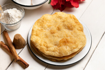 Christmas fritters with piloncillo and cinnamon on a white background. Mexican food