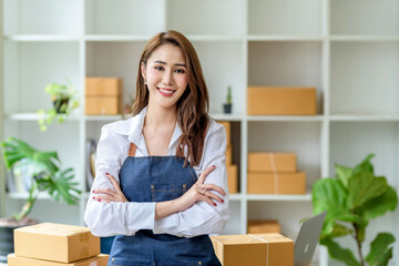 Beautiful young Asian business owner woman smiling looking at camera with crossed arms.