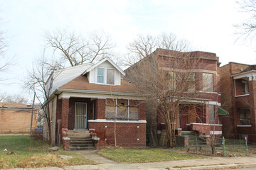 Abandoned Chicago bungalow next to a boarded up two-flat in Englewood