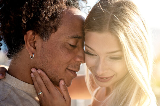 Closeup beauty portrait of attractive couple embracing each other. Multiethnic people in love. Wedding. Proposal.