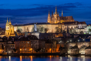 Fototapeta na wymiar A picturesque evening view of the Prague additions - the Charles Bridge over the Vltava River and the illuminated Prague Castle with the Goitic Cathedral.