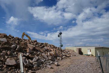 Rocky rubble at construction site with cellular tower and equipment