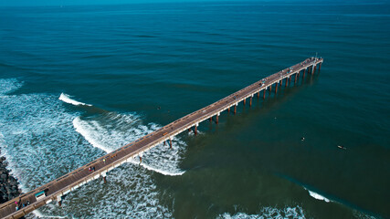 Fototapeta na wymiar High angle drone view of St Augustine villano beach fishing pier off the east coast of Florida with turquoise atlantic ocean waves and foam