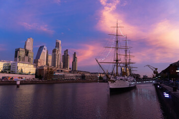 Puerto Madero, Buenos Aires, sunset in the city, pink sky, reflection in the water of city and boat