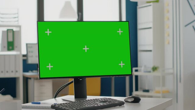 Close up of green screen on computer in empty business office. Isolated template and mock up background with chroma key on monitor, nobody in workplace. Mock-up copy space app on display