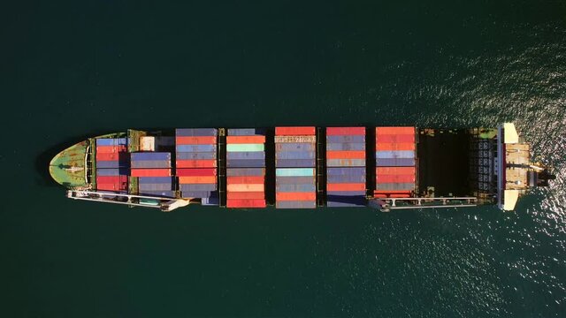 Aerial view of small feeder container cargo vessel at anchor 