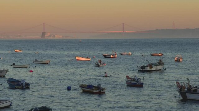Fishing port at Paco de Arcos, Oeiras, Portugal, at twilight. 25 de abril bridge in Lisbon on background