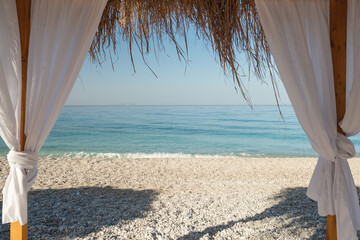 Fototapeta na wymiar Canopy beach bed with white curtains on the sand beach