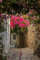 Picturesquare narrow pass with bougainvillea flowers in Old Datca, Turkey