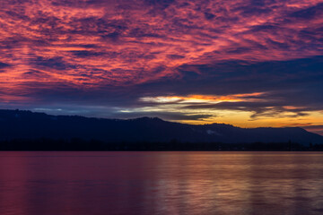 Fototapeta na wymiar Sonnenuntergang mit kraftvollen roten Wolken am Himmel am schönen Bodensee 