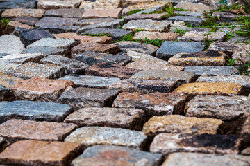 Cobblestone street texture. Regular shapes of cobblestone road, abstract background of old cobblestone pavement close-up.