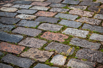 Cobblestone street texture. Regular shapes of cobblestone road, abstract background of old cobblestone pavement close-up.