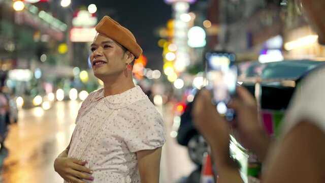 Asian lgbtq guy friend in woman clothes meeting together in the city and using smartphone photography together at night. Diversity sexual equality, lgbtq pride and transgender cross-dressing concept