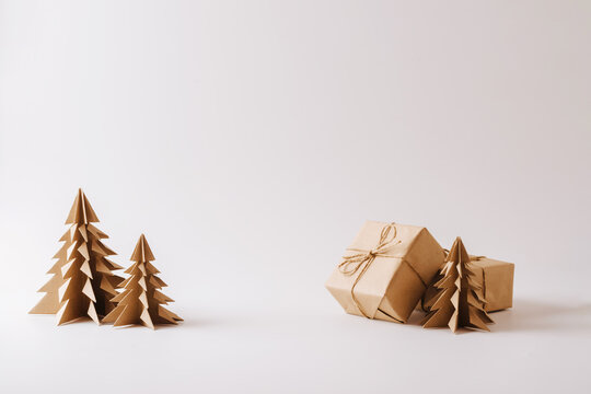 Origami tree made of paper, gifts light background. Festive composition for Christmas or New Year copy space
