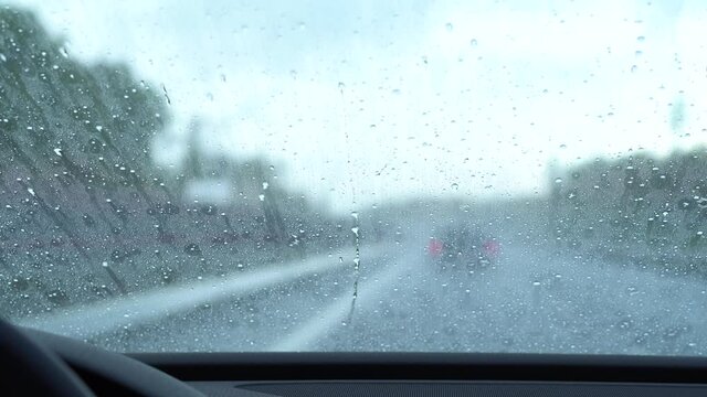 Rain drops run up the windshield because of anti-rain coating. Car polish.