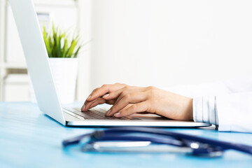 Close up of female doctor hands with laptop