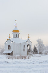 Winter landscape - a small Orthodox church at dusk in a winter square