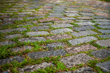 Cobblestone street texture. Regular shapes of cobblestone road, abstract background of old cobblestone pavement close-up.