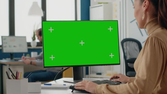 Close up of woman using computer with isolated green screen on display. Company worker looking at chroma key with mock up template and background on monitor. Blank mockup copy space