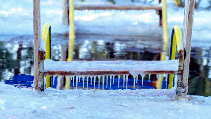 A large ice hole with stairs is ready for swimming walruses.
