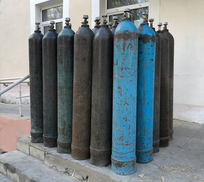 A lot of oxygen cylinders are on the porch of the hospital