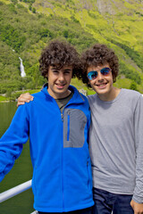 happy twins smiling at camera in norway fjords