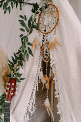 Photozone in the form of a tipi decorated in boho style