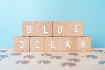 「BLUE OCEAN」と書かれた積み木とコイン - obrazy, fototapety, plakaty
