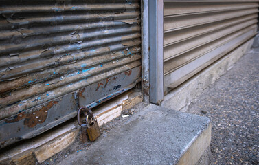 Closed shop shutter and padlock. Economic crises and bankruptcies.