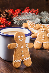 Gingerbread man cookie stands by a coffee cup. - 474615792