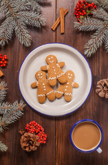 Gingerbread man cookies are on the wooden table with coffee cup. - 474615793