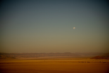 A moon visible after sunset seen from Elim Dune, Namib Desert, Namibia