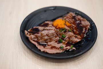 Fresh Wagyu beef sushi with sauce.