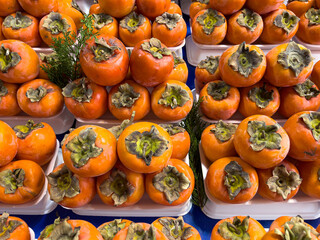 Fresh harvest Persimmon fruits on a farmers market stall