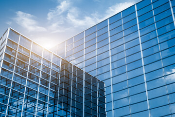 Modern office building with glass facade on a clear sky background. Transparent glass wall of...